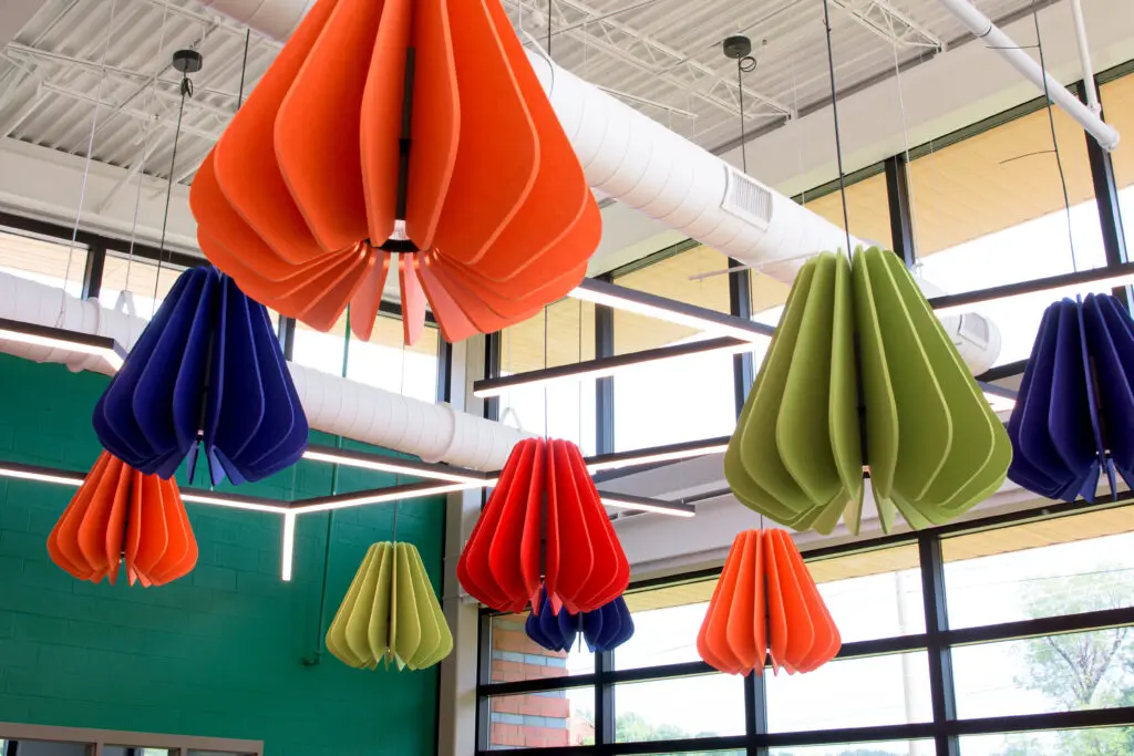 Unique and colorful hanging lighting fixture in lime green, dark blue, dark orange, and light orange.